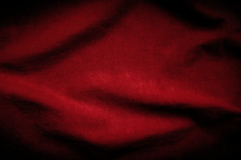Close-up of wrinkled red fabric texture with dark shadows