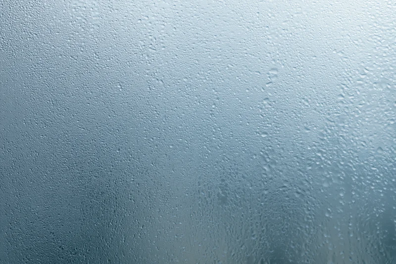 Close-up of water droplets on a fogged glass window surface
