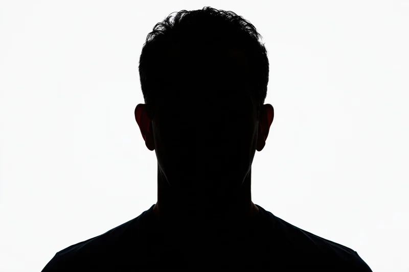 Silhouette of a man's head and shoulders facing forward against white background