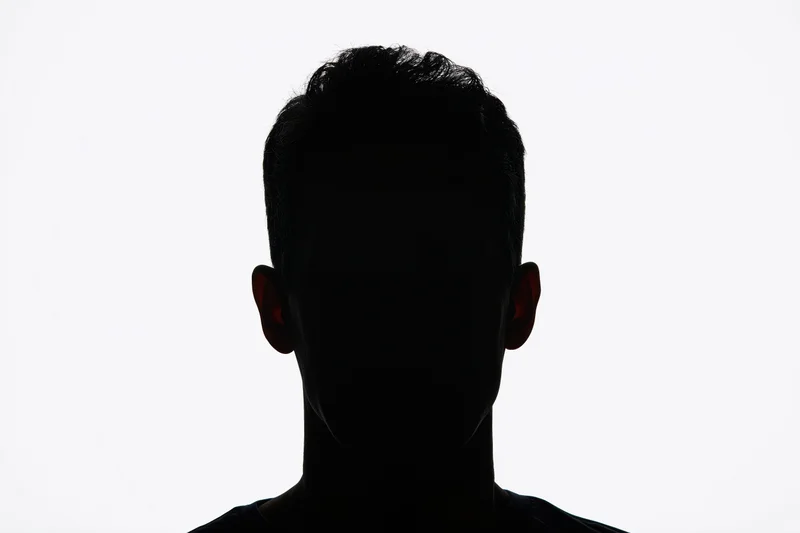 Silhouette of a man's head and shoulders facing forward against white background