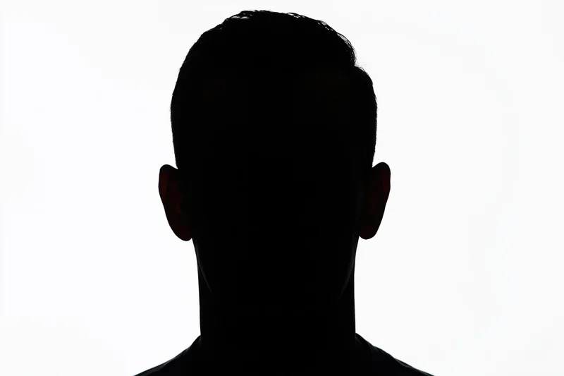 Silhouette of a man's head and shoulders facing forward against white background