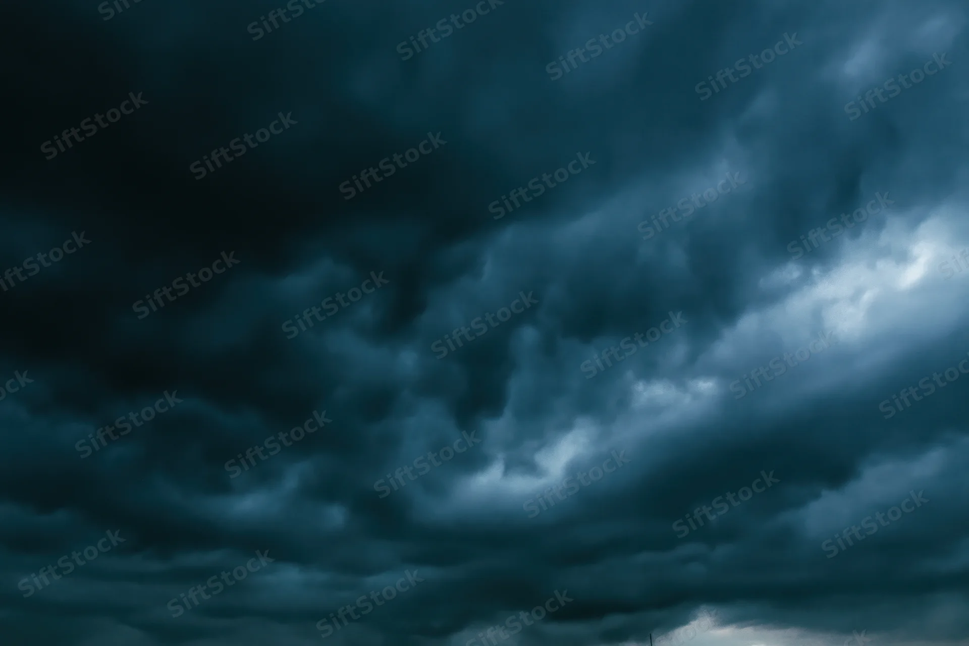 Dark stormy sky filled with heavy roiling clouds showing turbulent weather conditions