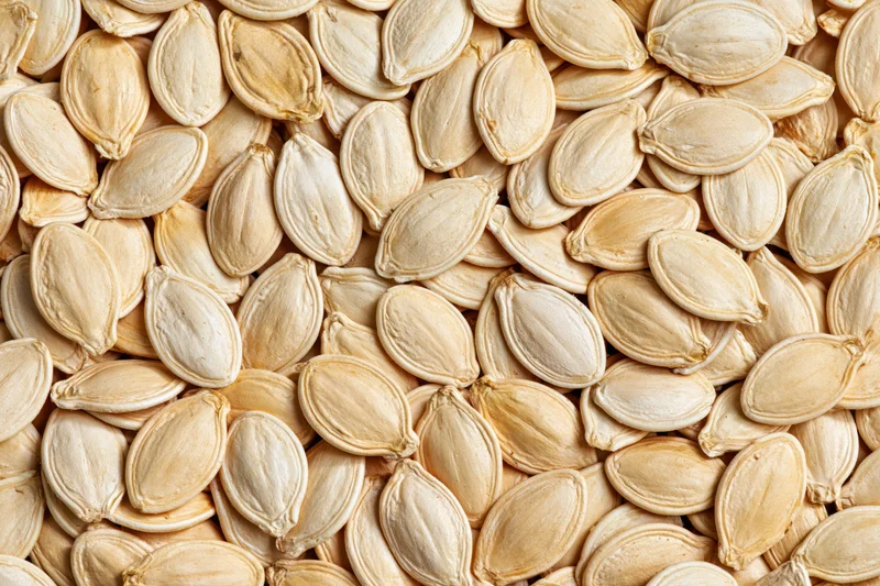 Dried pumpkin seeds densely scattered filling the frame