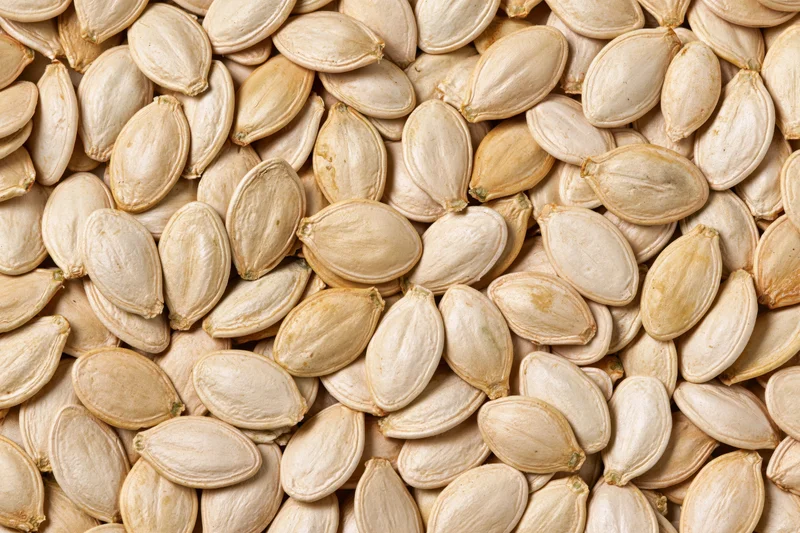 Dried pumpkin seeds densely scattered filling the frame