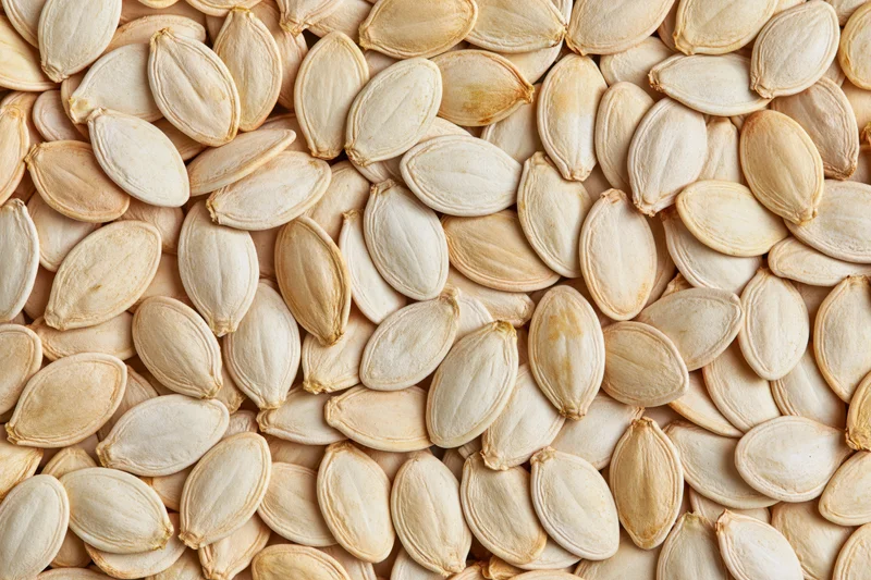 Dried pumpkin seeds scattered densely filling the frame