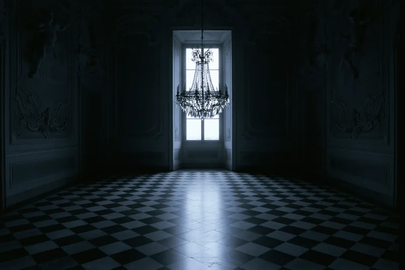 Empty baroque ballroom interior with ornate plaster moldings and checkered floor, light entering through doorway window