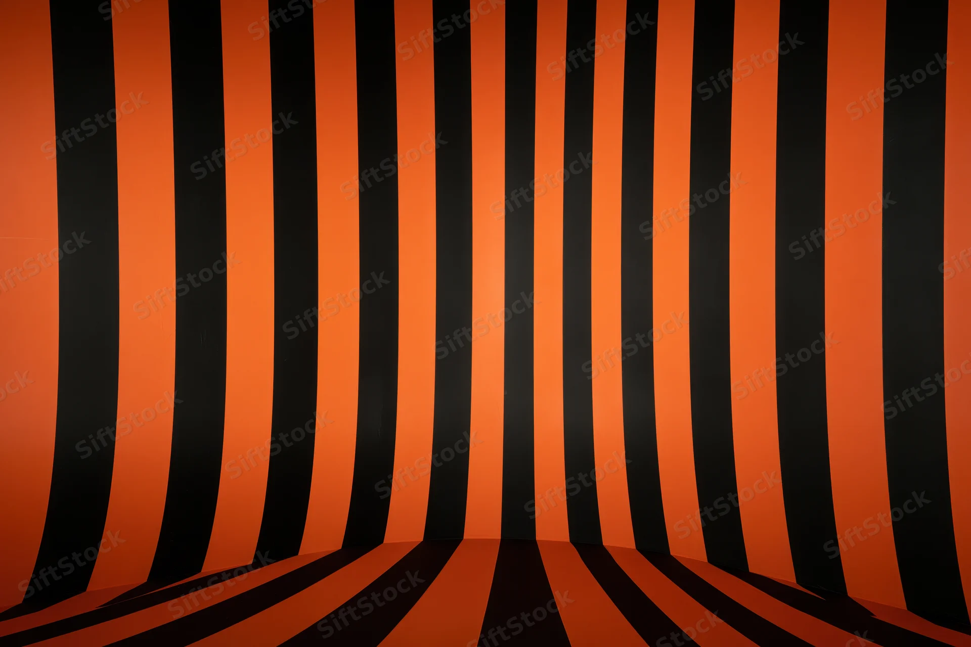 Curved orange and black striped backdrop in a studio space creating an infinity illusion