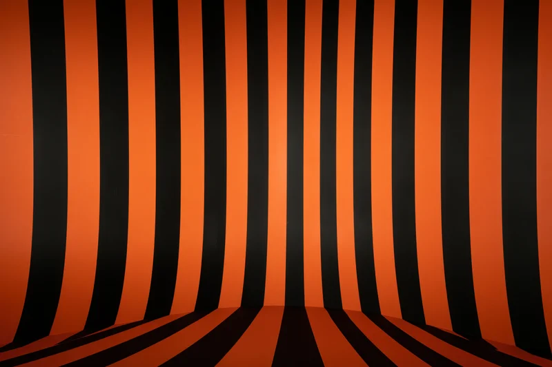 Curved orange and black striped backdrop in a studio space creating an infinity illusion