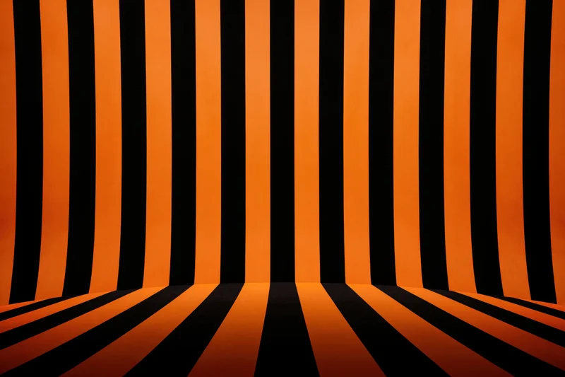 Orange and black striped backdrop curving into infinity in a studio corner