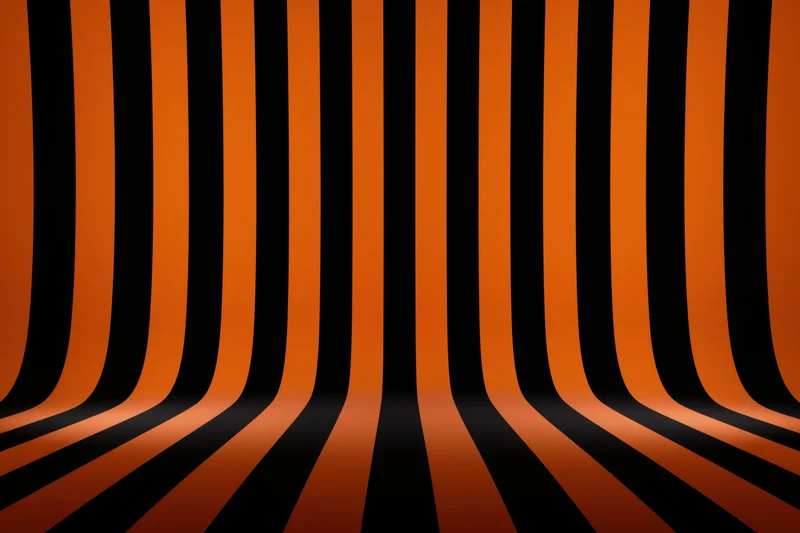 Curved orange and black stripes creating an infinite tunnel perspective in a studio backdrop