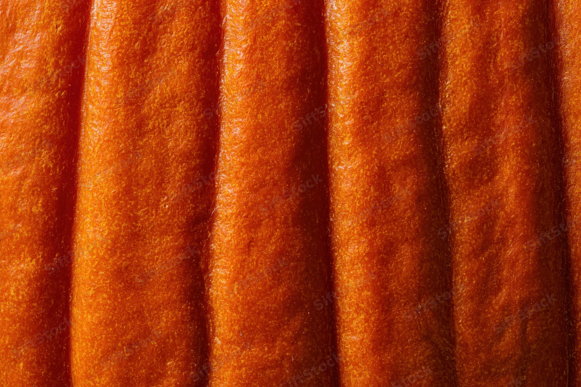 Close-up of pumpkin skin surface showing ridged texture and orange color