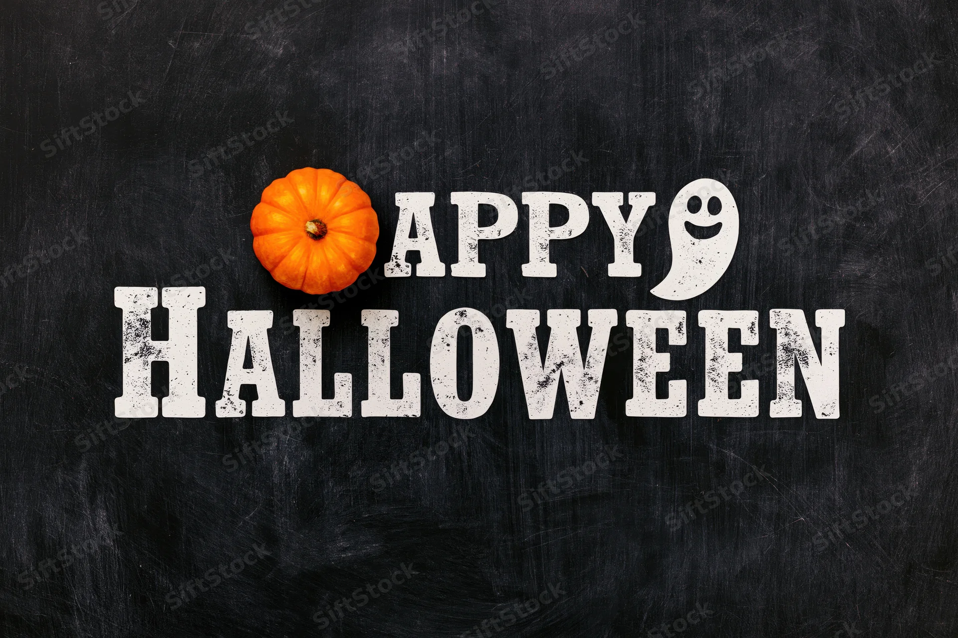 Flat lay halloween greeting card design with pumpkin and ghost text on chalkboard surface