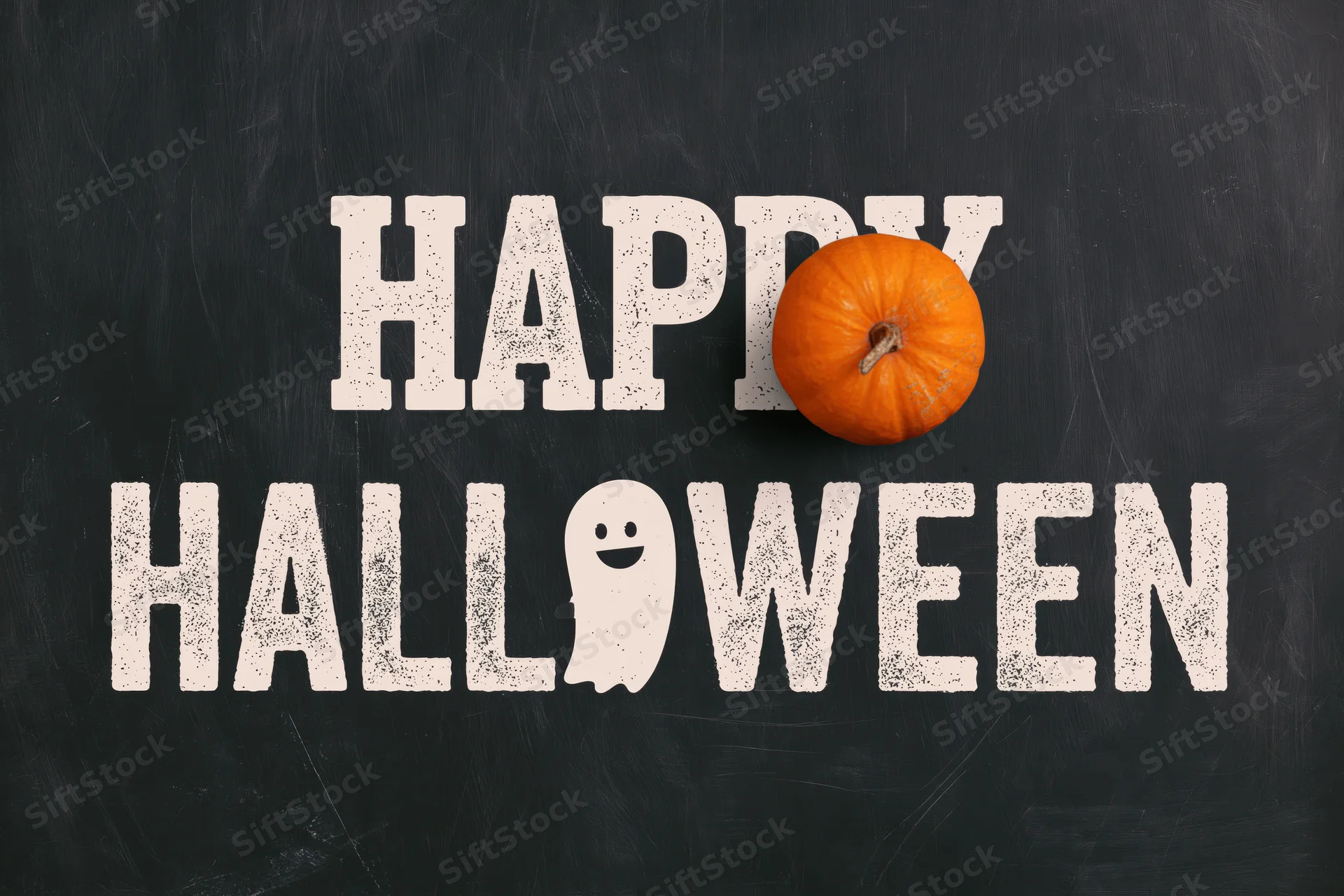 Flat lay halloween greeting card design with happy halloween text, pumpkin, and ghost on black chalkboard surface