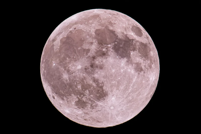Full moon centered against pure black night sky