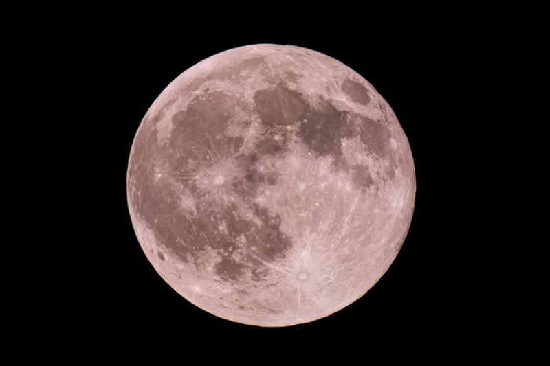 Full moon centered against pure black night sky