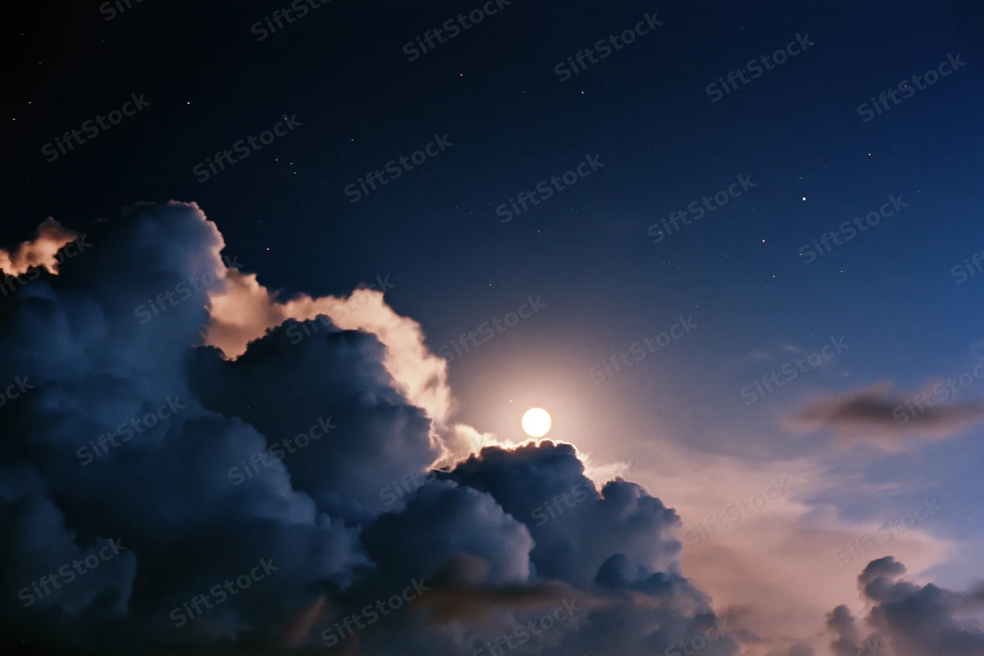 Full moon rising above dense dark storm clouds in night sky