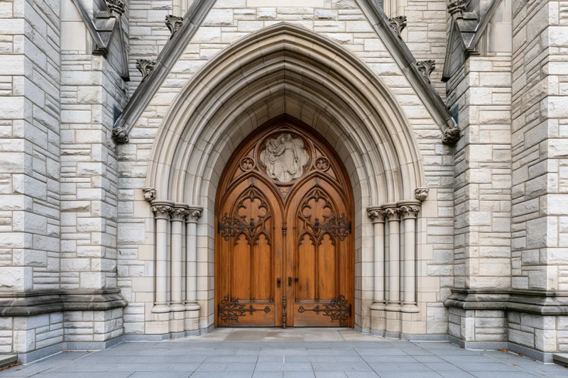 Gothic church entrance with ornate carved wooden double doors under a pointed stone arch