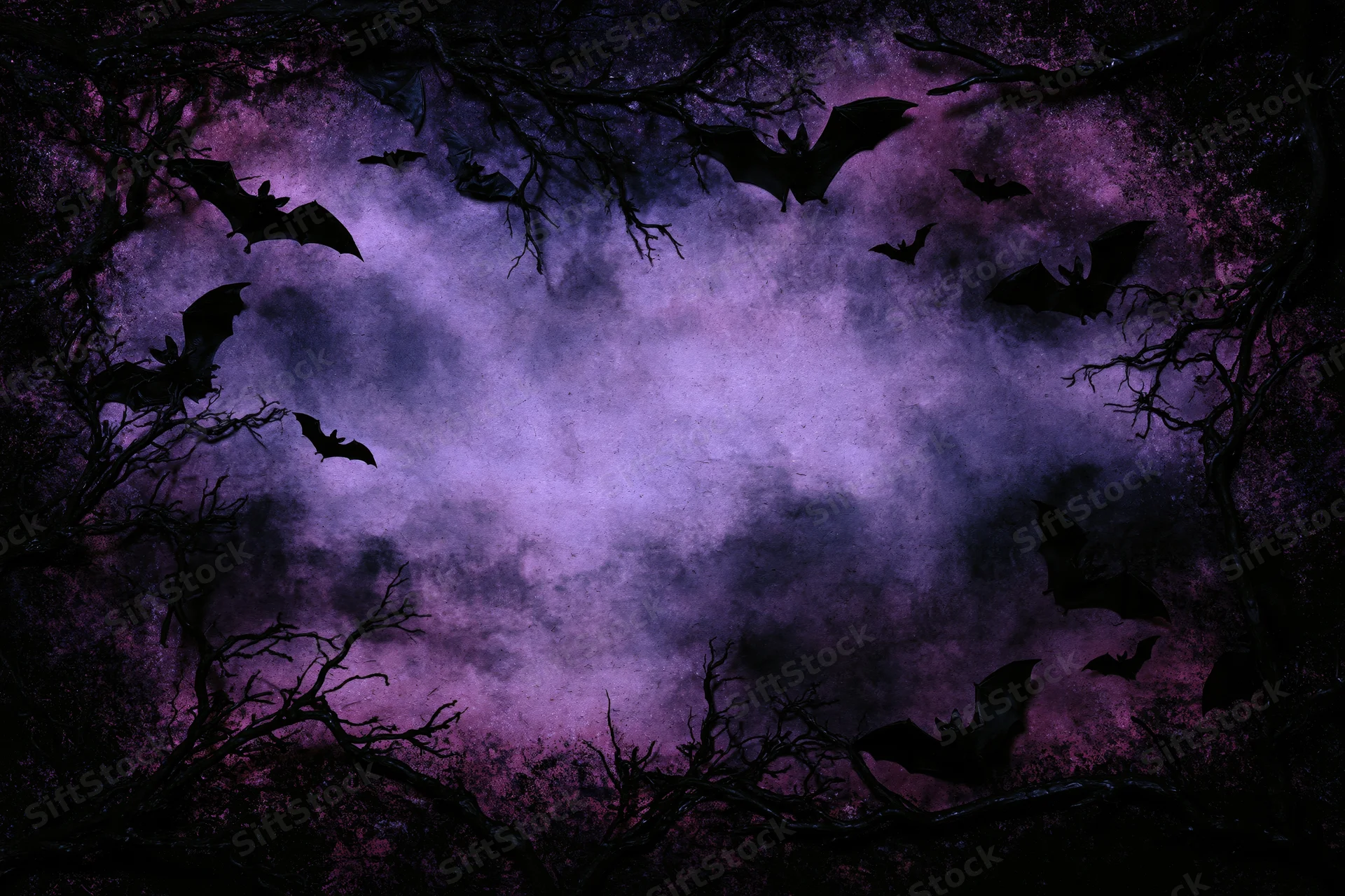 Silhouetted bats flying through a purple night sky framed by bare tree branches