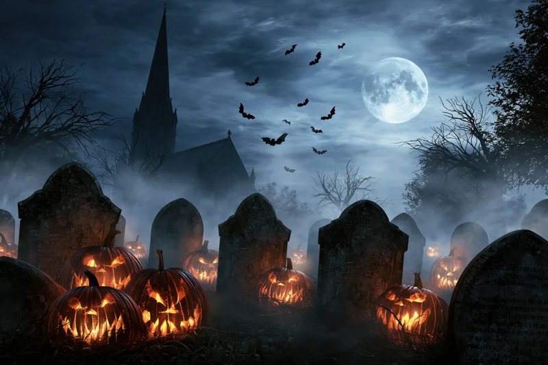 Carved jack-o-lanterns glowing among tombstones in a foggy graveyard at night with a full moon and bats flying overhead