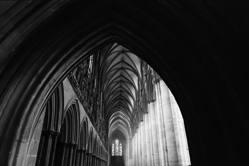 View through a pointed arch into the vaulted nave of a gothic cathedral interior