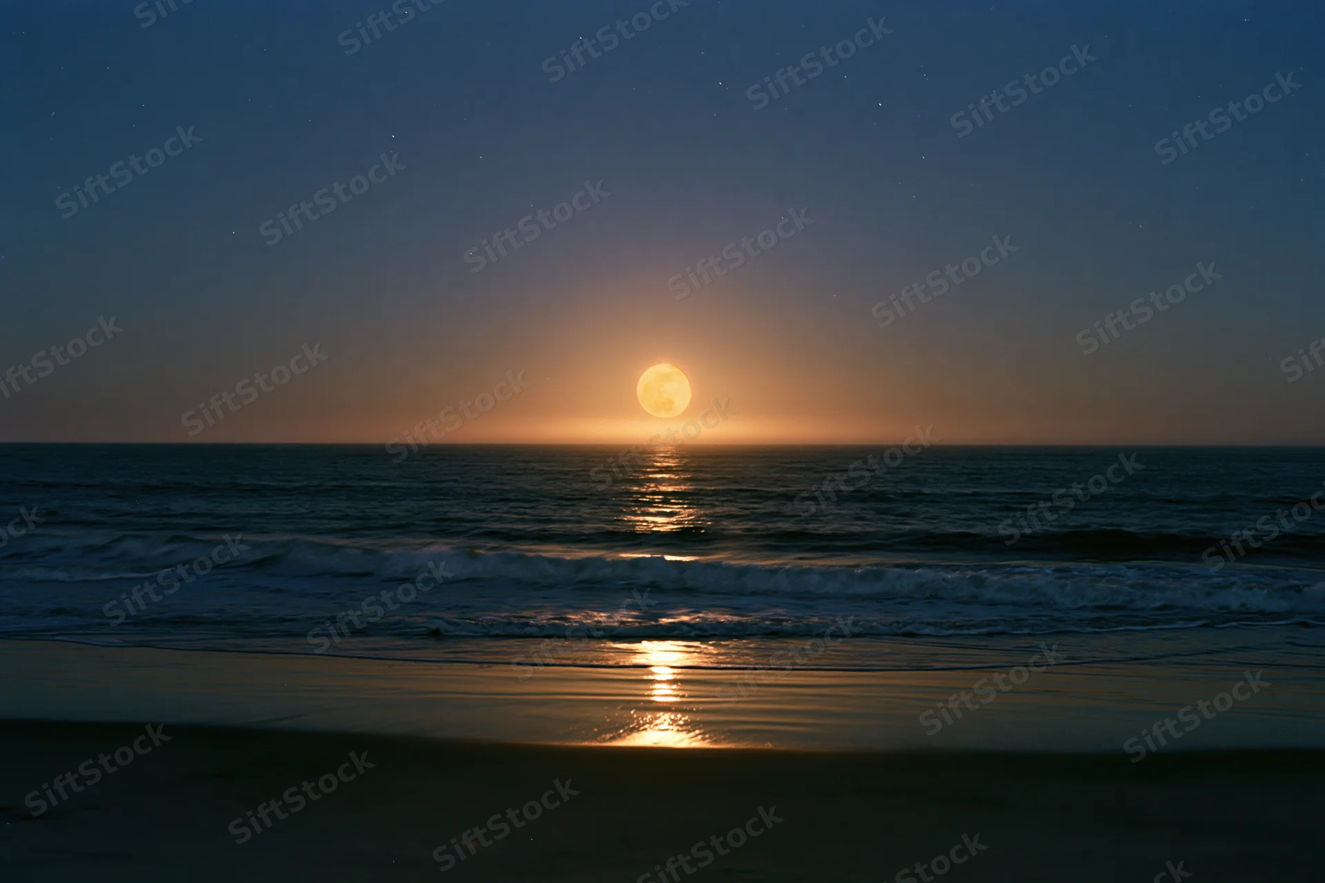 Full moon rising over calm ocean at night with stars and reflection on water
