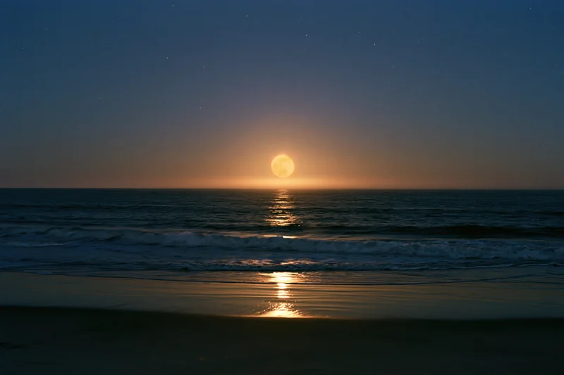 Full moon rising over calm ocean at night with stars and reflection on water