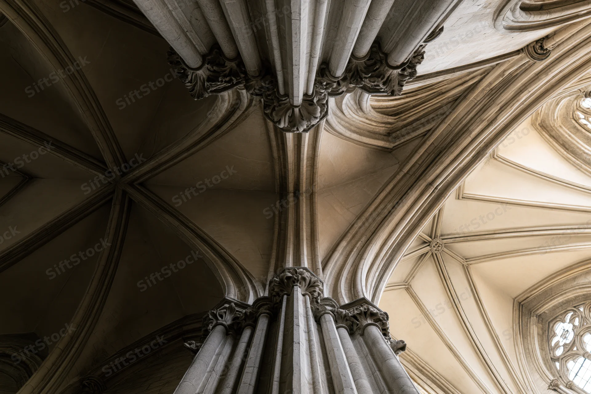Upward view of gothic cathedral stone columns and ribbed vault ceiling
