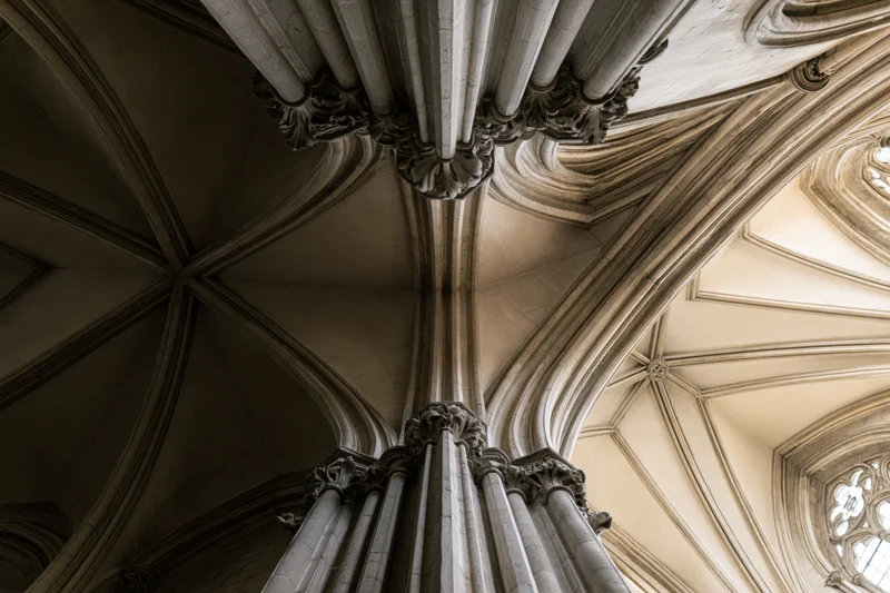 Upward view of gothic cathedral stone columns and ribbed vault ceiling