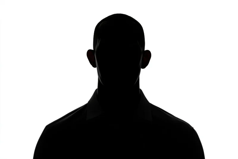 Silhouette of a man facing forward in a dark form against white background