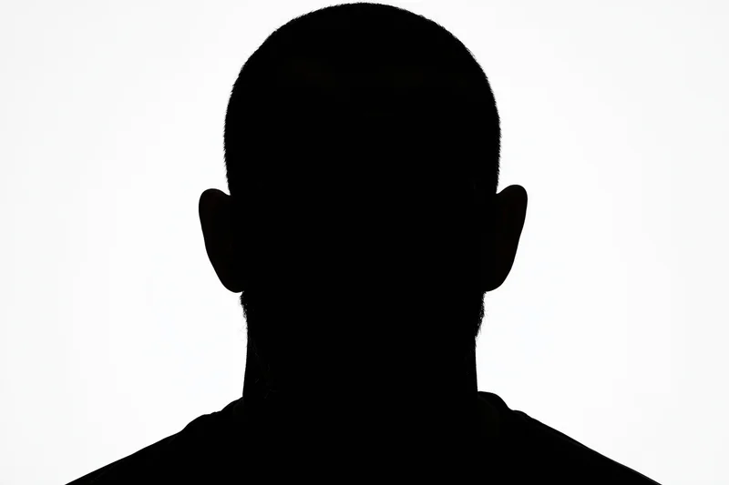Silhouette of a man facing forward showing head and shoulders against white background