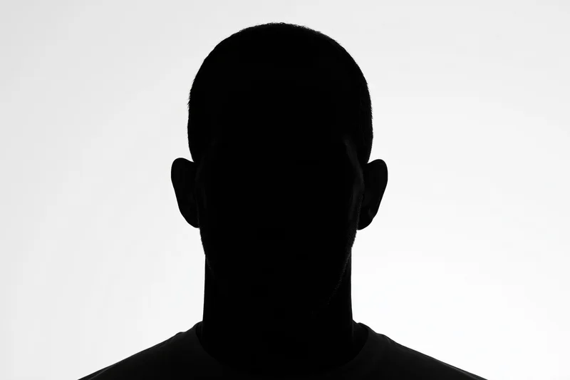 Silhouette of a man facing forward showing head and shoulders against white background