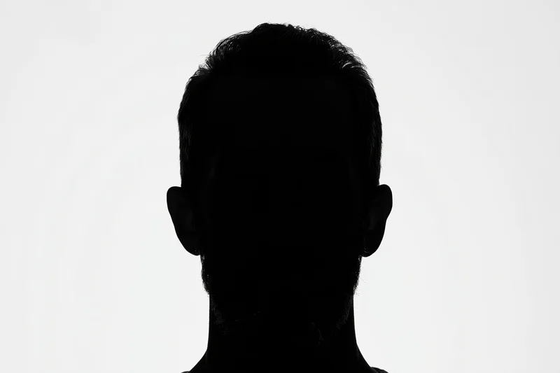 Silhouette of a man facing forward showing head and shoulders against white background