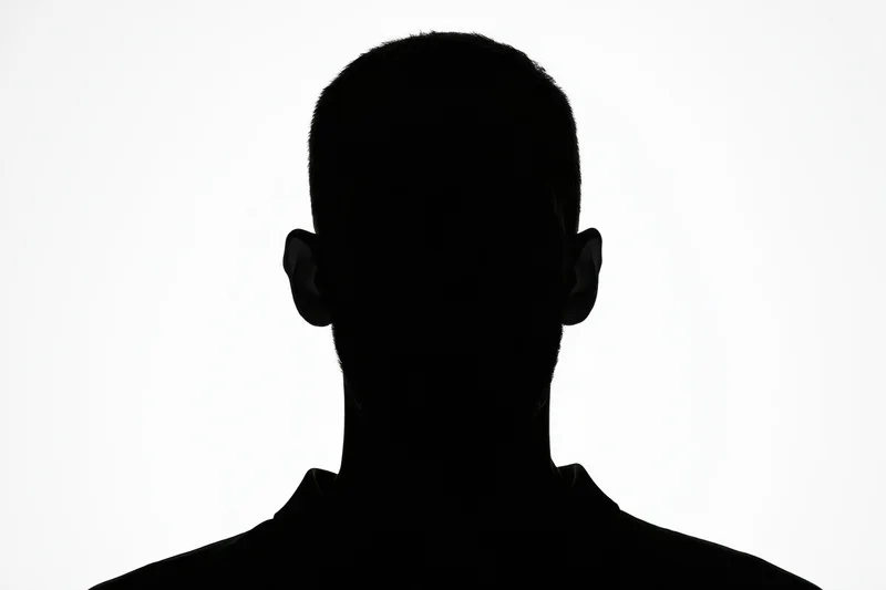 Silhouette of a man facing forward showing head and shoulders against white background