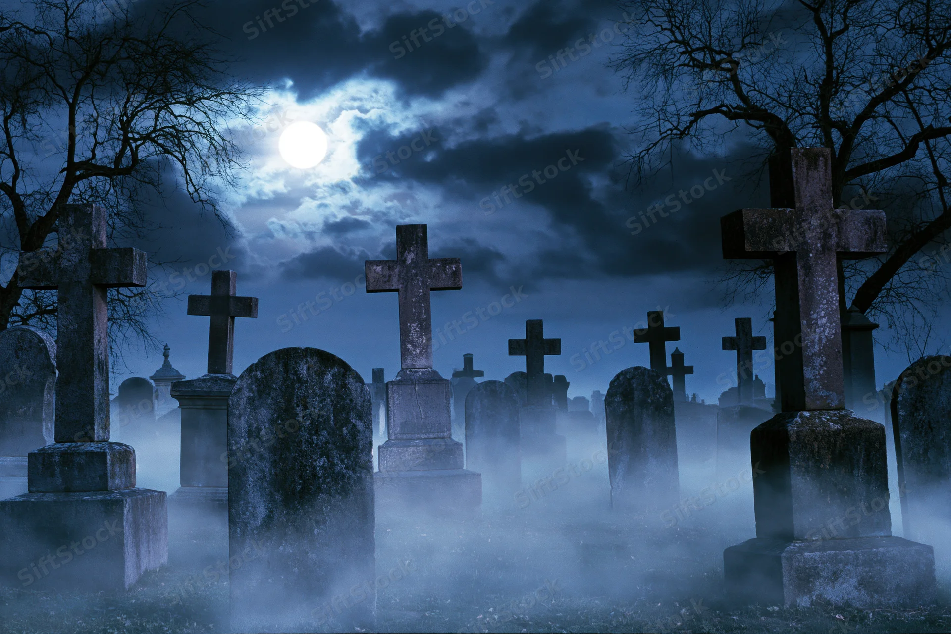 Old cemetery at night with weathered stone crosses and tombstones in fog under a full moon