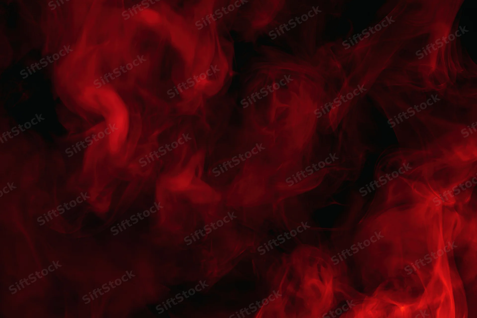 Red and crimson smoke swirling in dark abstract clouds