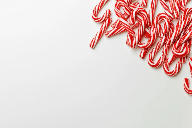 Candy canes scattered in corner on white background with copyspace