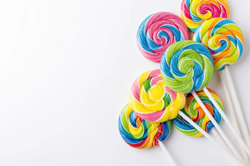 Colorful swirl lollipops arranged on white background with copyspace