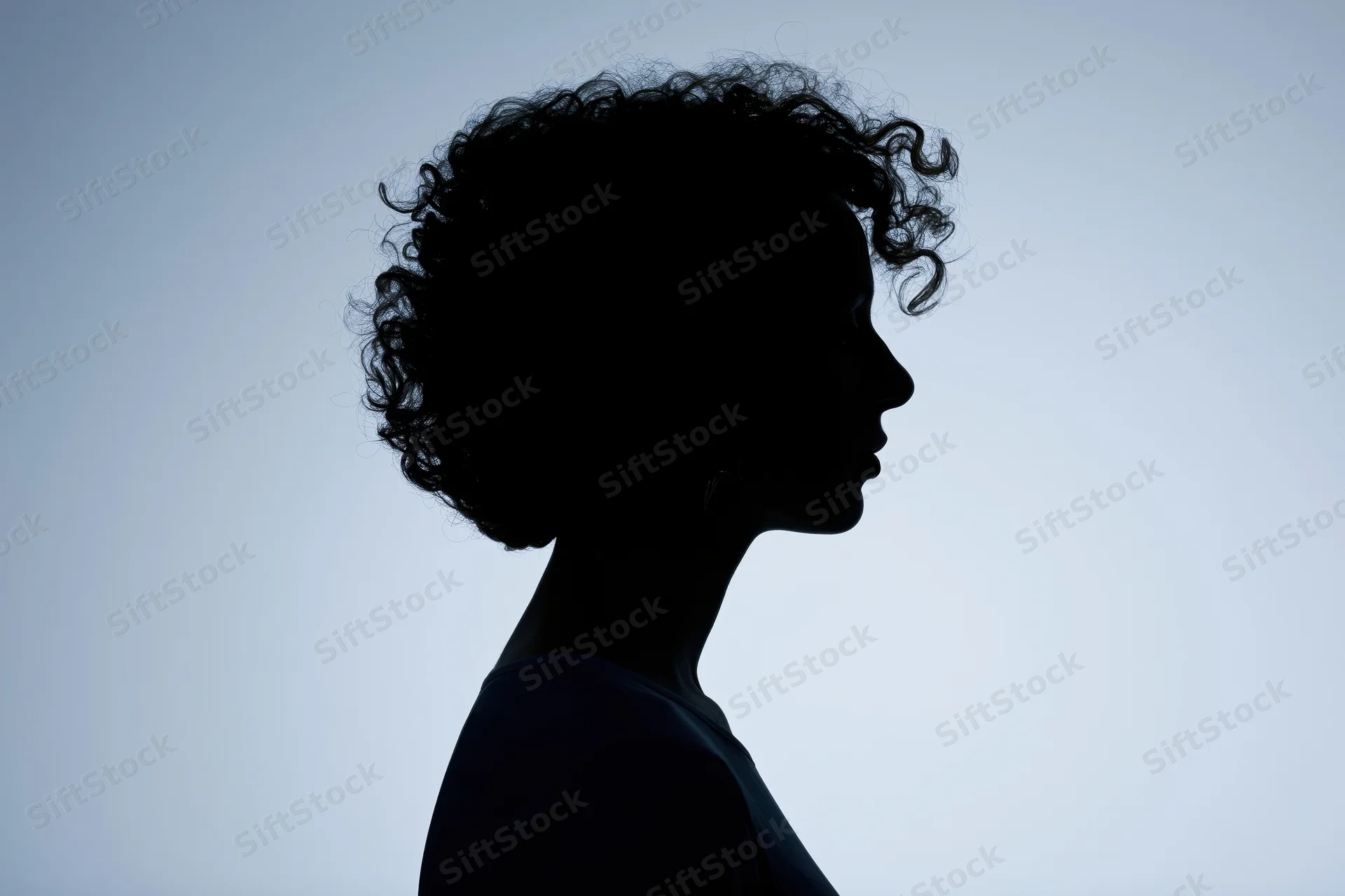 Silhouette of a woman with short curly hair in profile against a light background