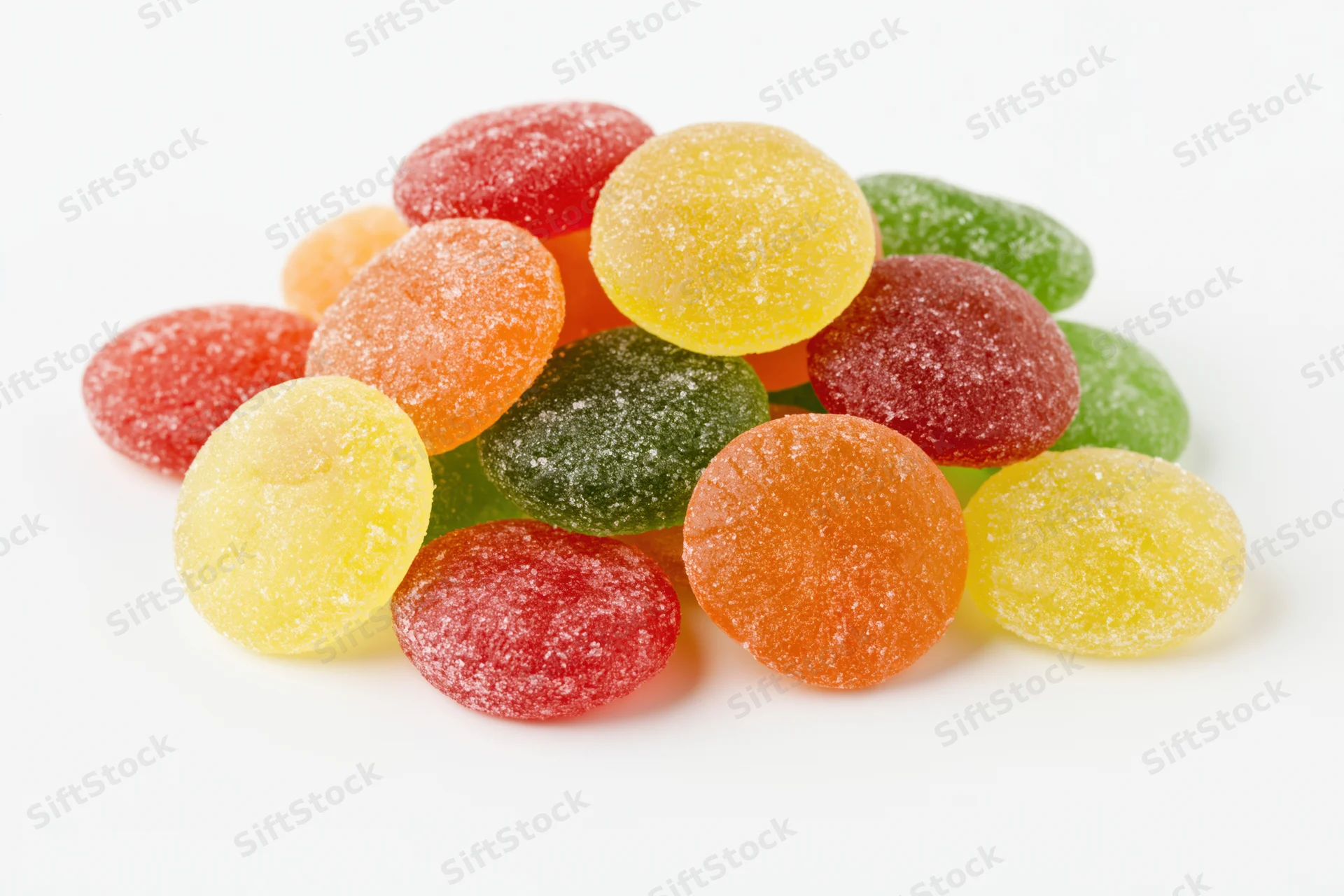 Pile of colorful sugar-coated jelly candy drops on white background