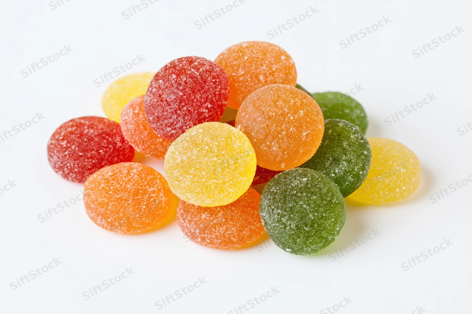 Pile of colorful sugar-coated jelly candy drops on white background