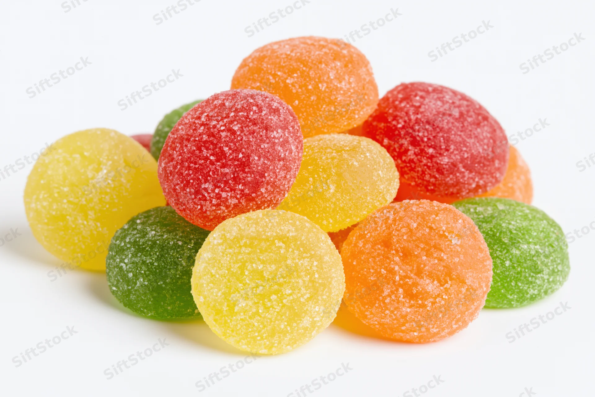 Pile of colorful sugar-coated jelly candy drops on white background