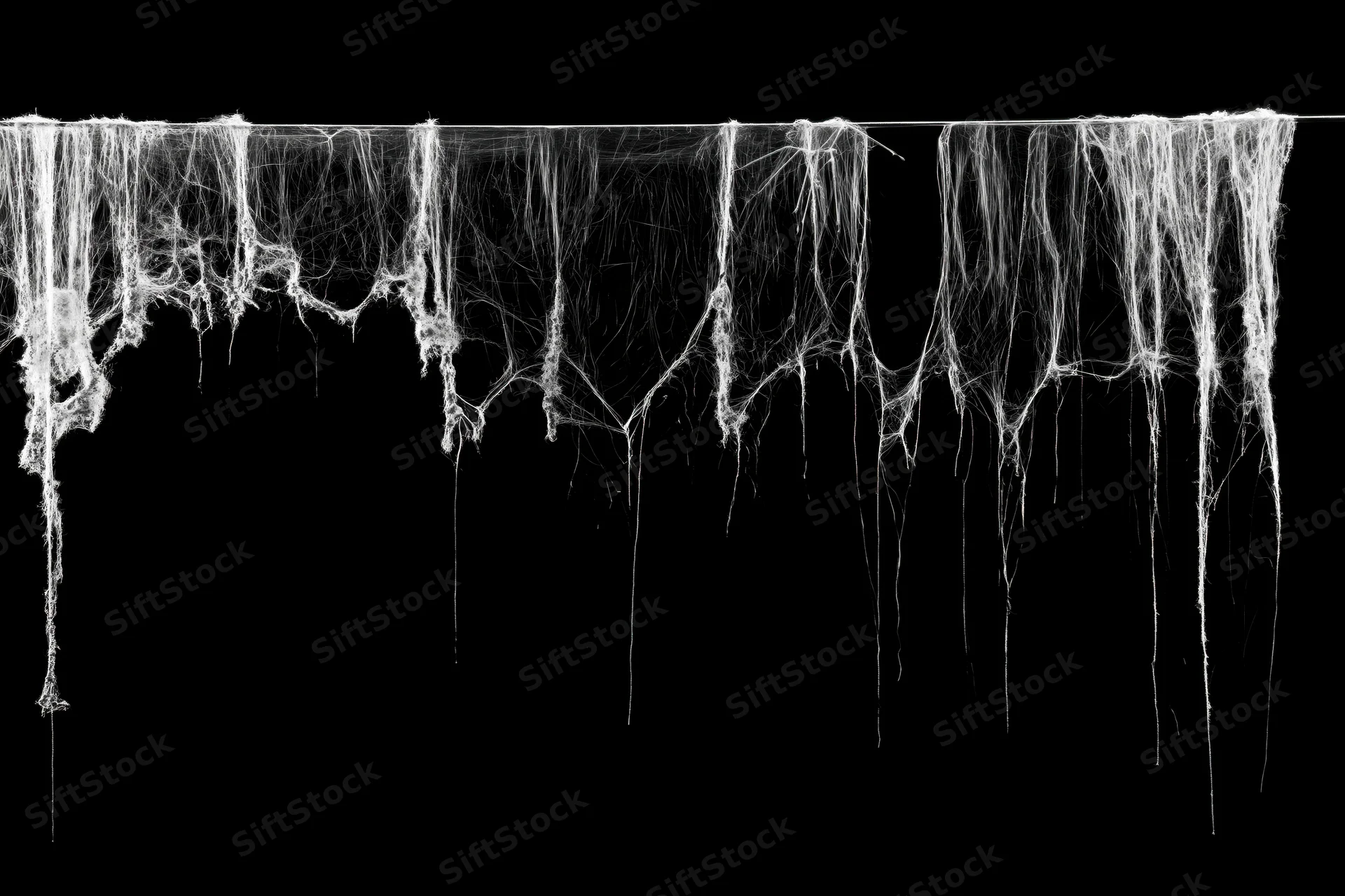 Tattered spiderweb hanging from a thin wire against black background