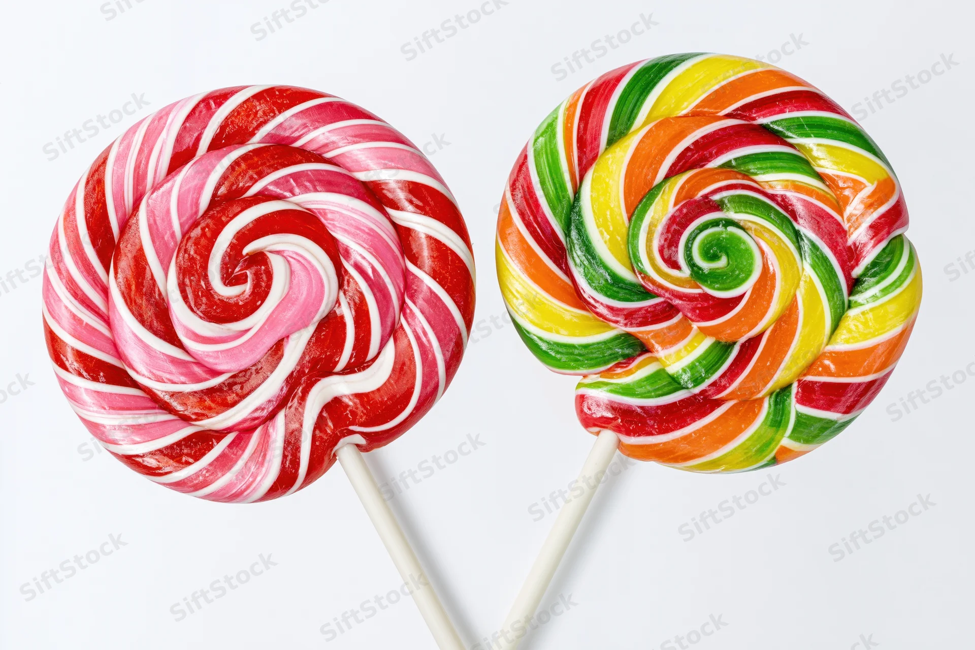 Two large round swirl lollipops on white sticks placed side by side against white background