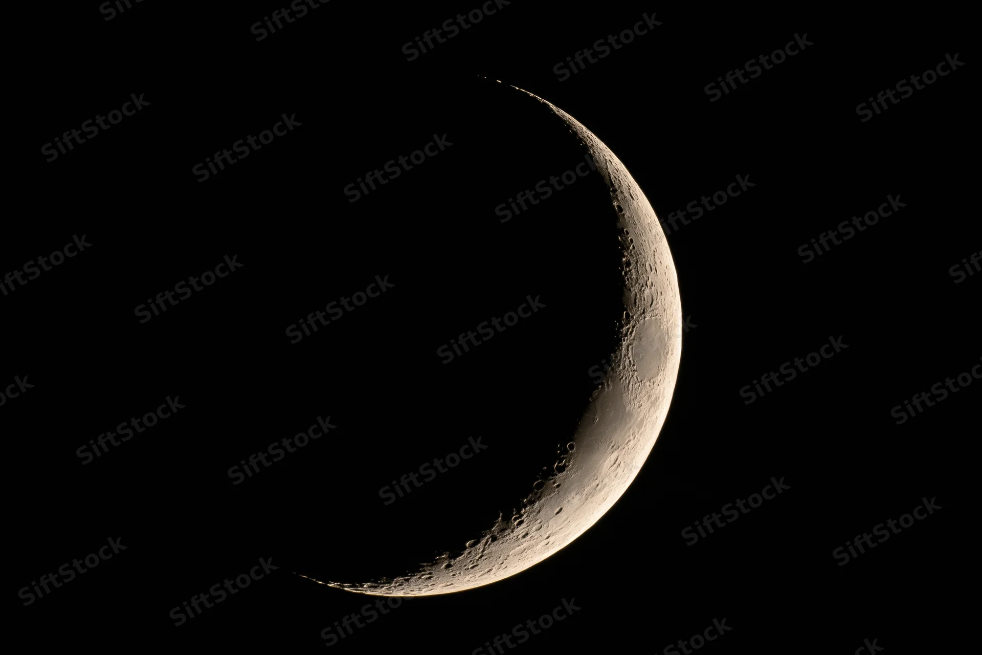 Waxing crescent moon phase against black night sky