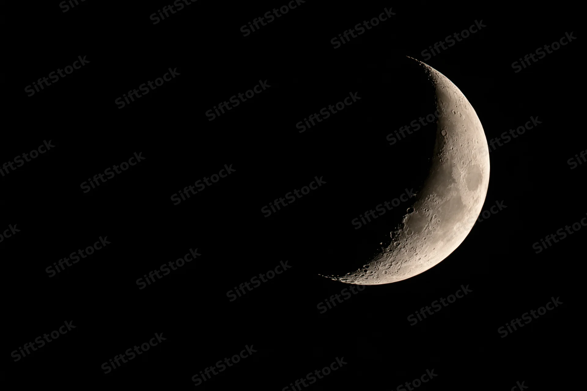 Waxing crescent moon phase against black night sky