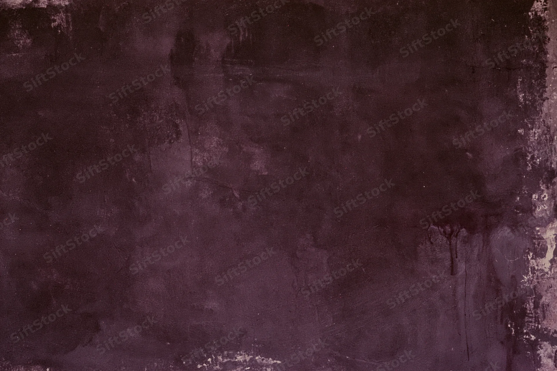 Weathered concrete wall surface with dark purple and gray stains and cracks filling the frame