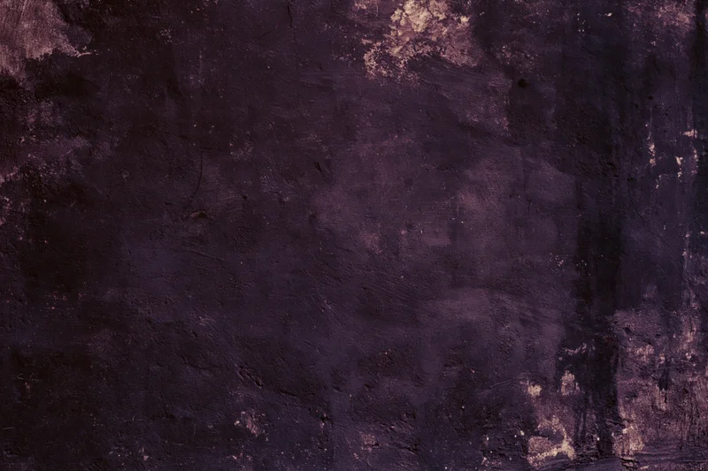 Weathered concrete wall surface filling the frame with dark purple and gray tones