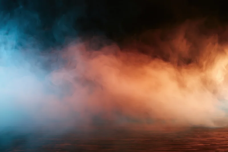 Colored smoke drifting above a dark textured surface