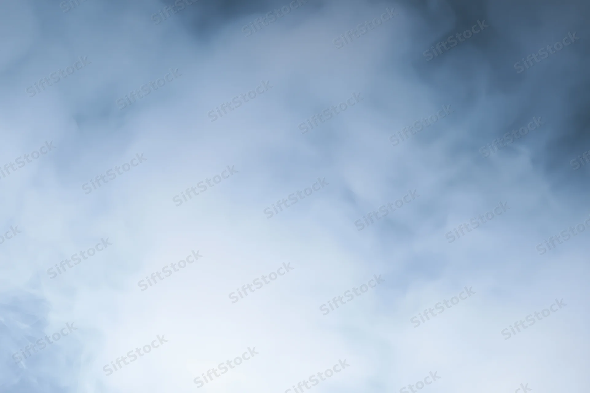 Wisps of white smoke drifting and swirling in a soft hazy atmosphere