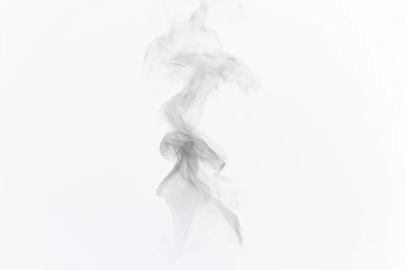 Wispy smoke plume rising and curling mid-air against a white background